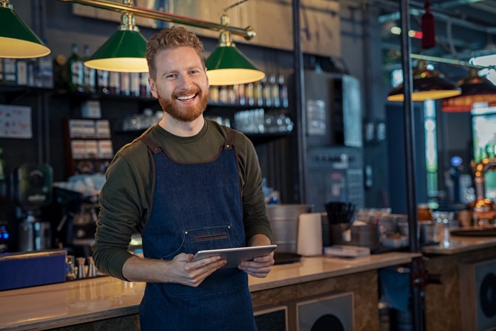 Bartender holding tablet to control the AV in restaurants and bars