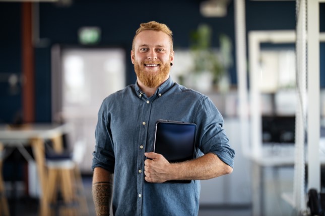 Smiling man holding a tablet